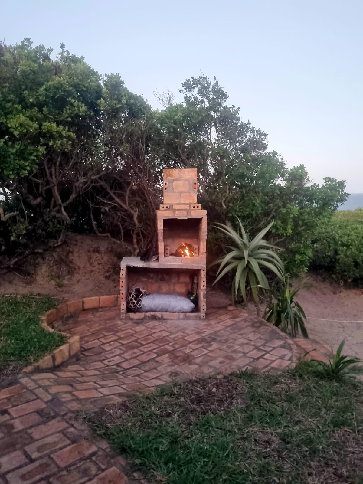 Braai lit at dusk with charcoal ready