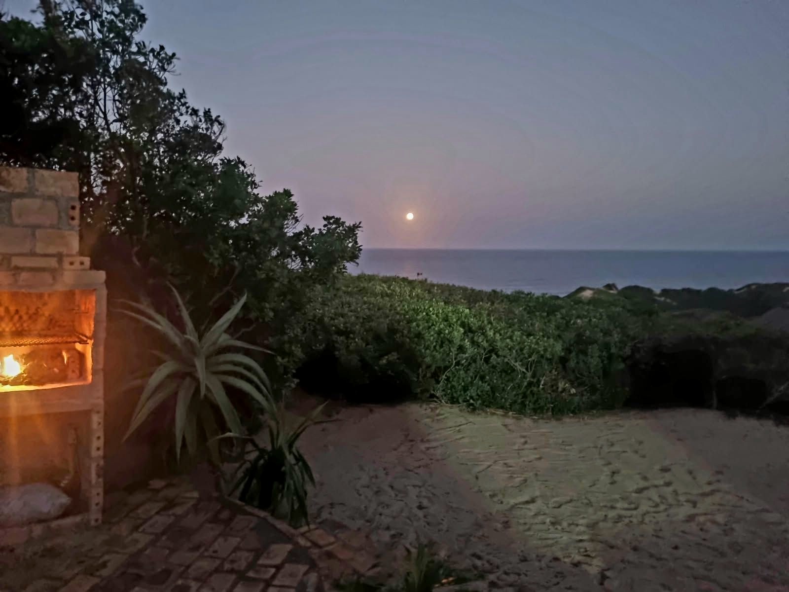 Braai area at dusk with the moon over the sea