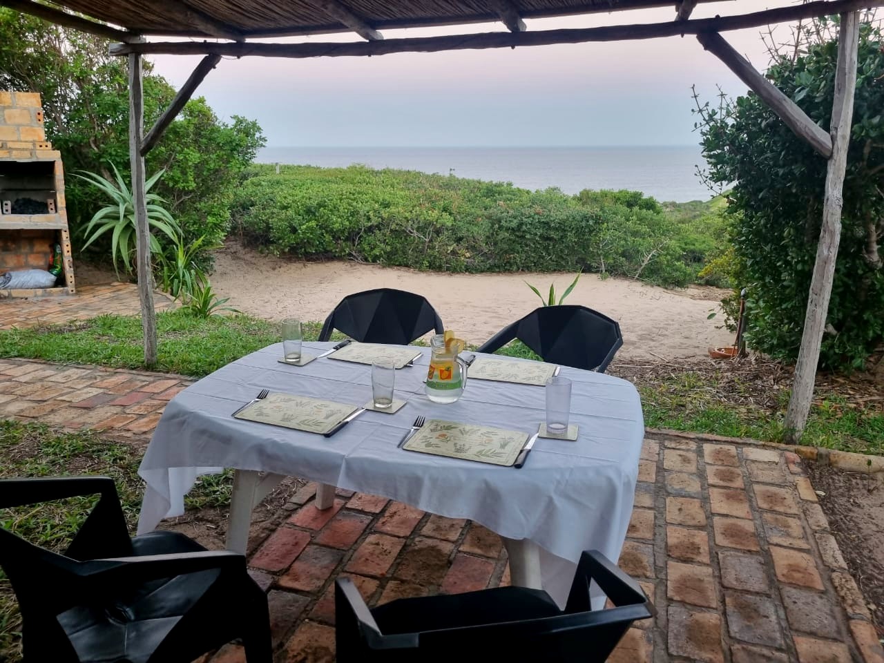A table laid under the thatch looking out to the sea at Terra Bella