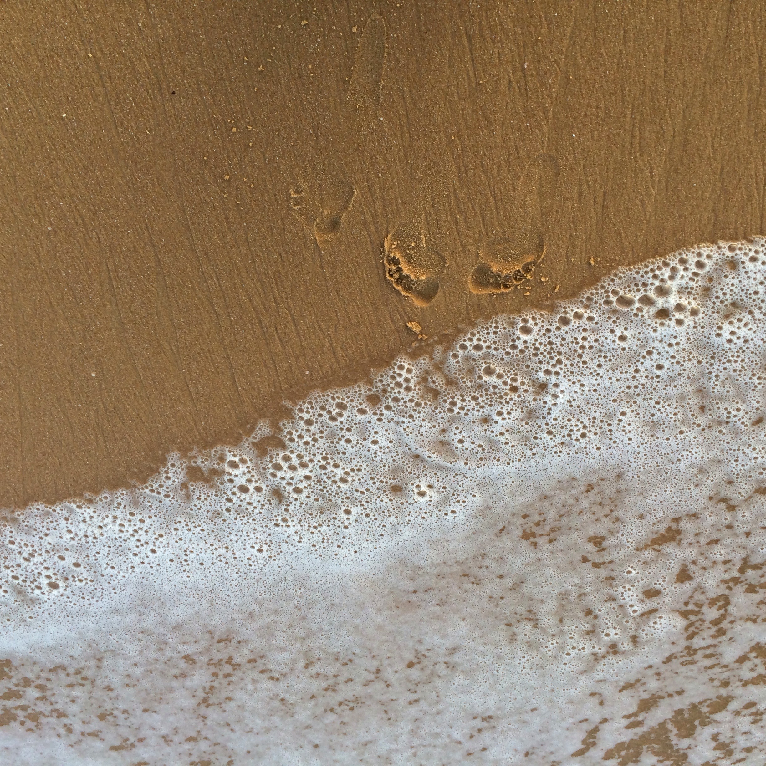 Bare footprints at the water's edge