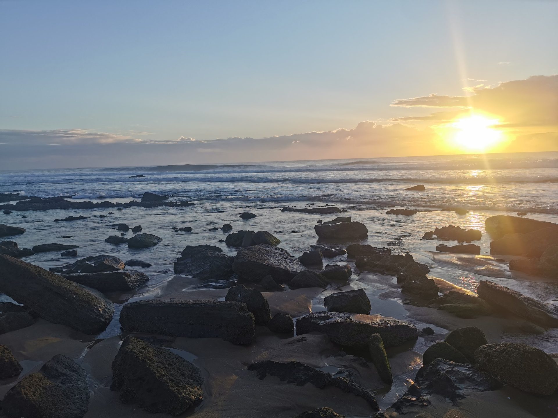 Sunrise over the rocky shore at low tide